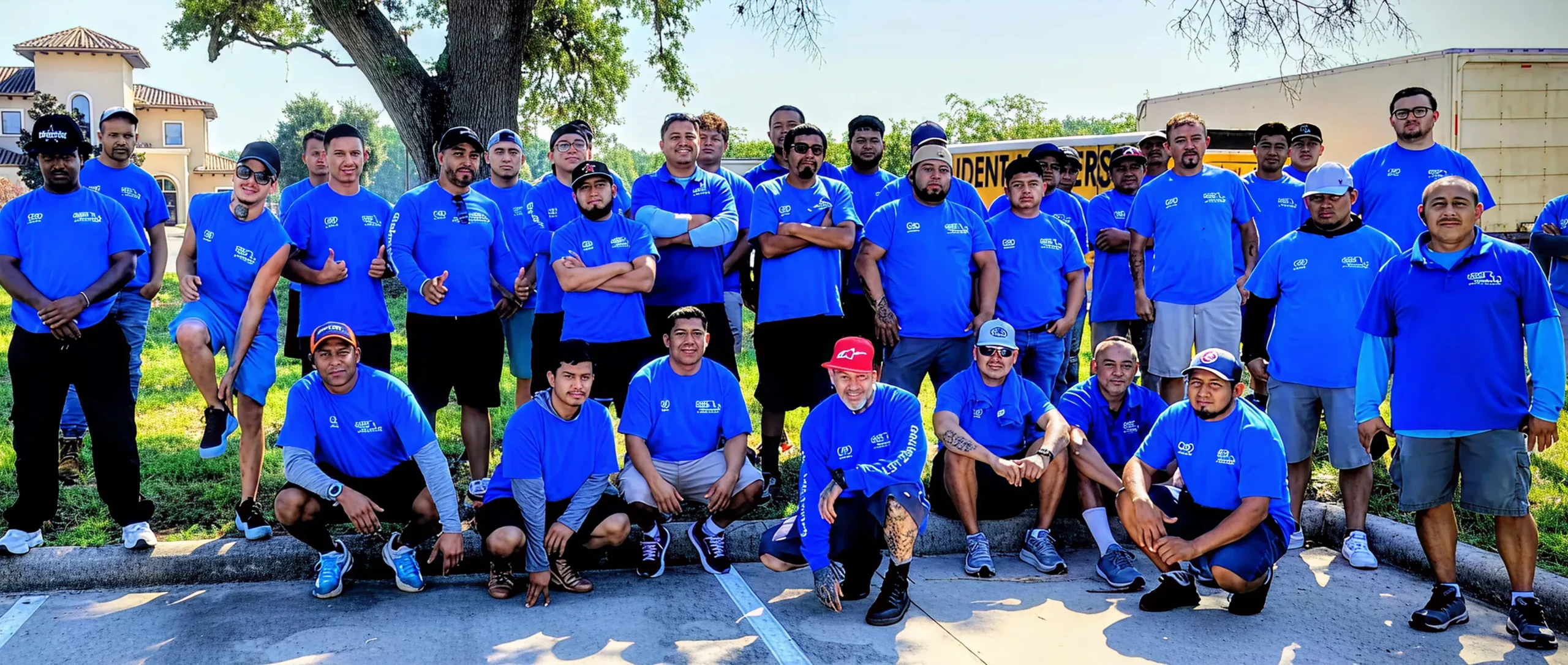 Professional team of Houston movers in blue uniforms standing together for a group photo.
